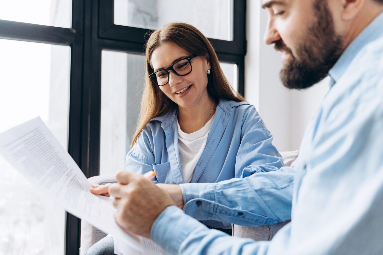 Financial advisor showing contract details to smiling client
