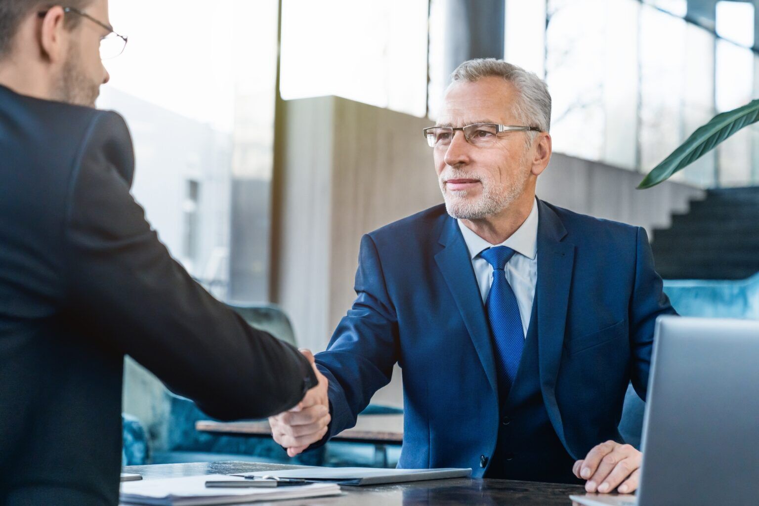 Handshaking between business partners after making a deal indoors