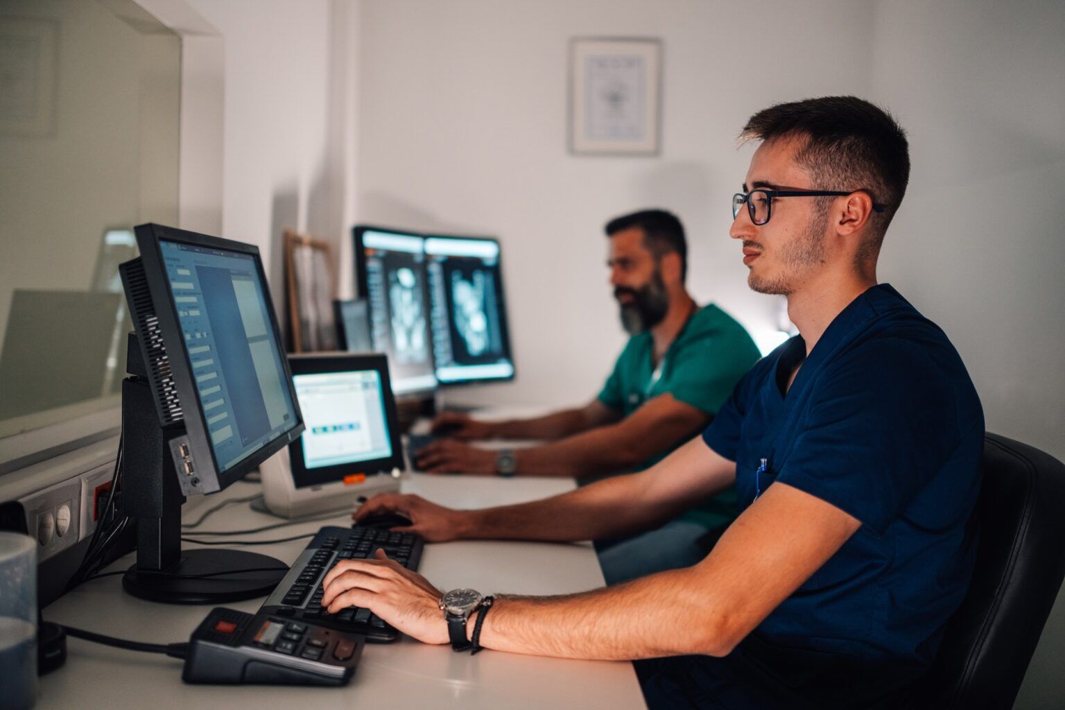 Radiology team reviewing patient scans on computer monitors