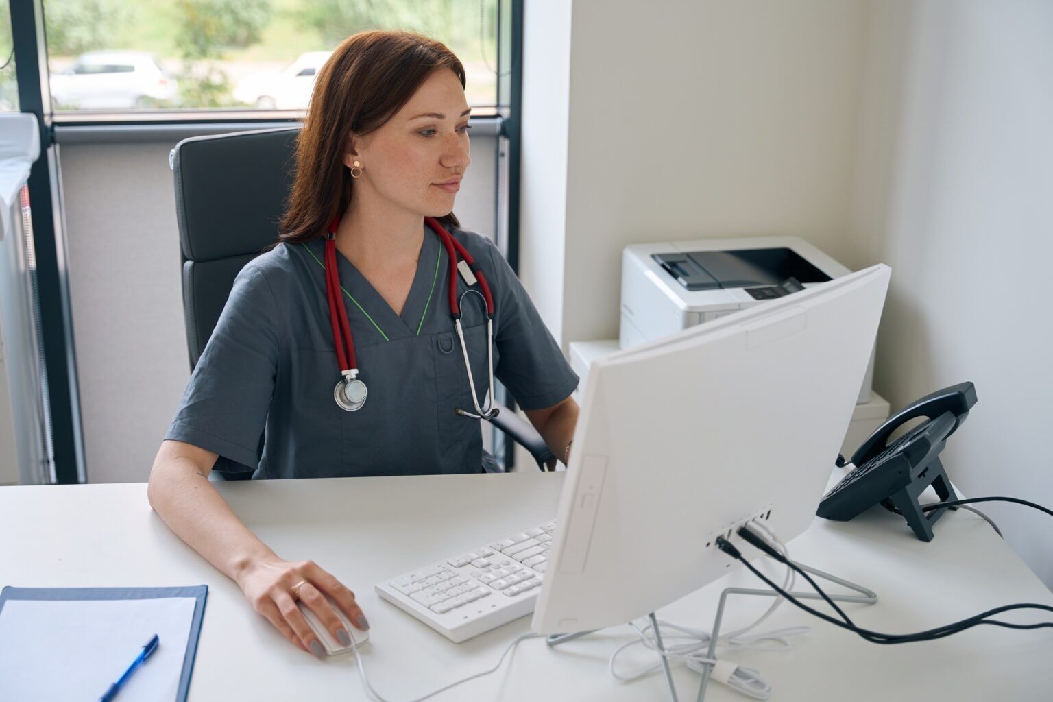 Concentrated female doctor using computer in her office