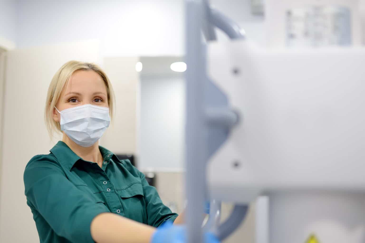 Female technician adjusts X-Ray machine. Female radiologist is going to take an Xray of patient