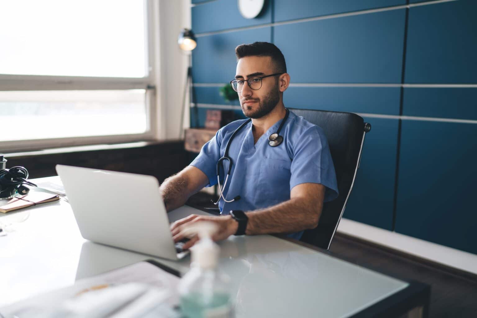 Serious doctor working on computer in hospital