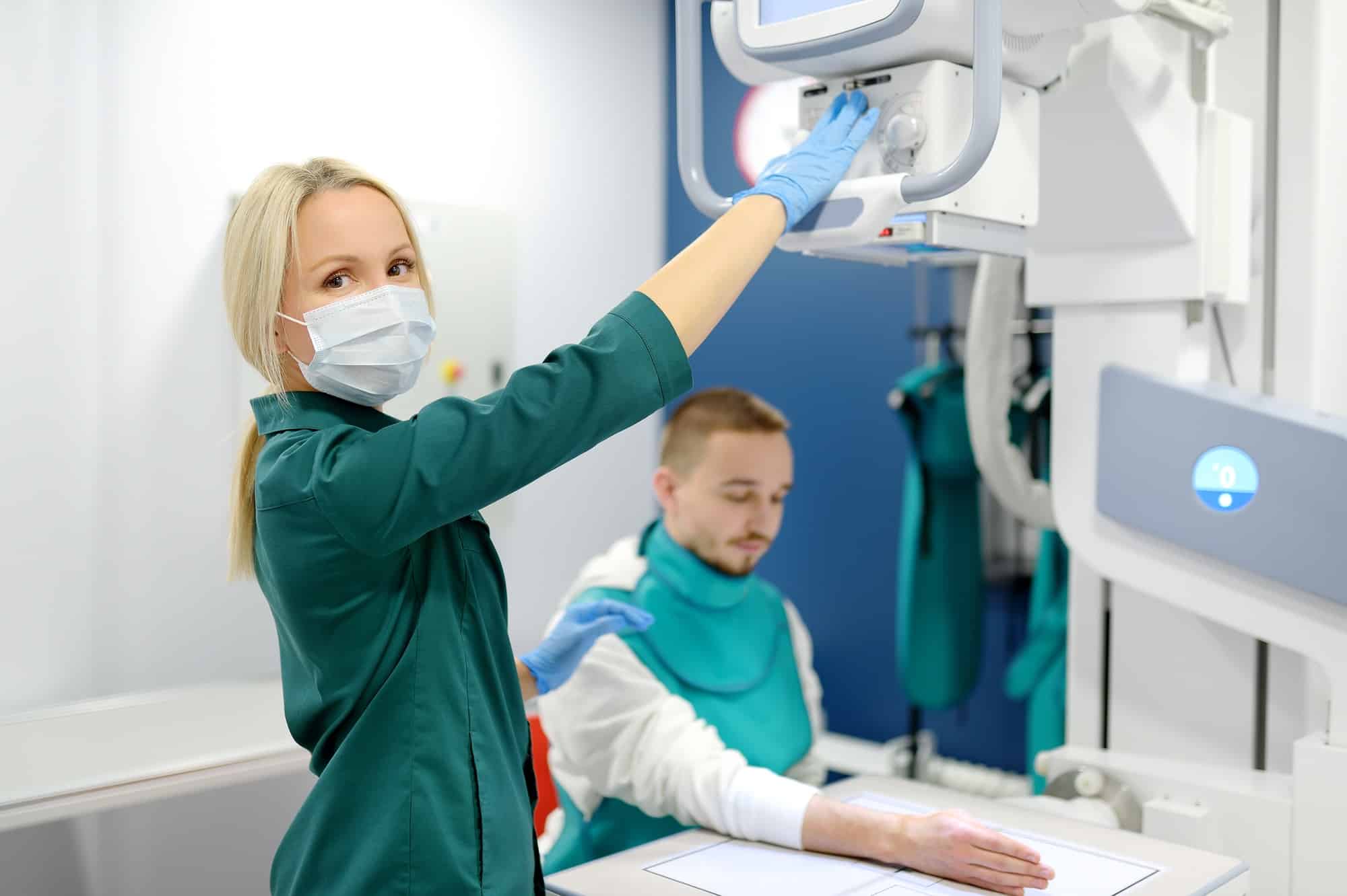 Young man having x-ray shot of broken hand in x ray room in modern clinic