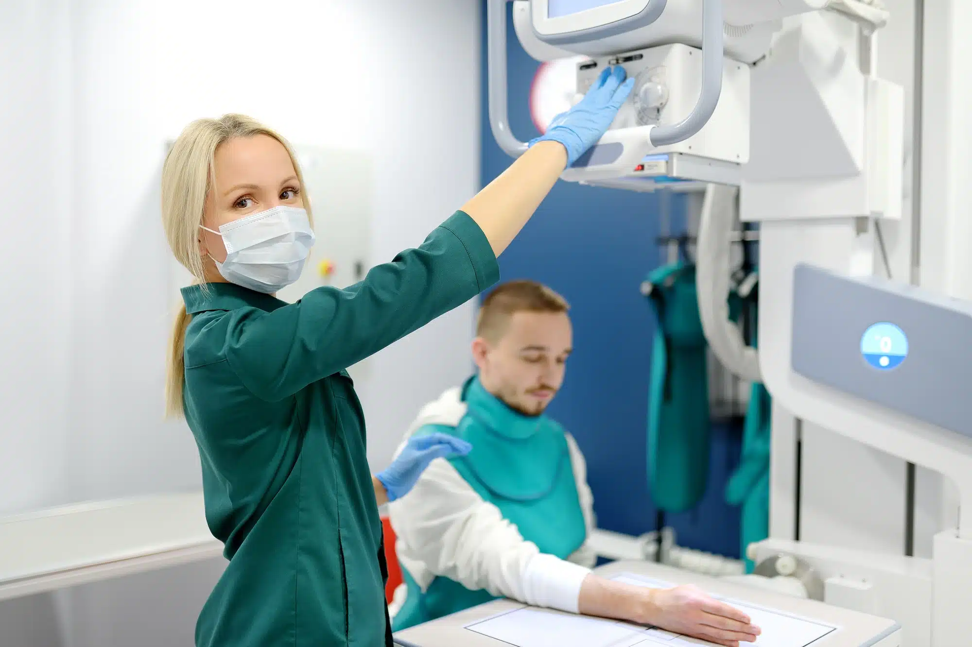 Young man having x-ray shot of broken hand in x ray room in modern clinic