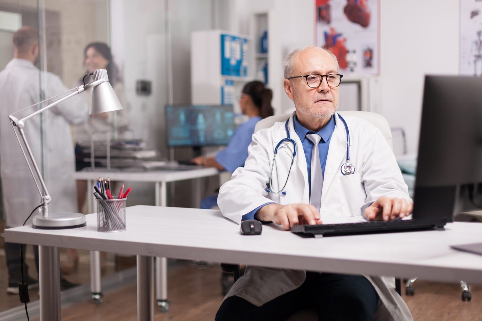 Senior man doctor working on computer